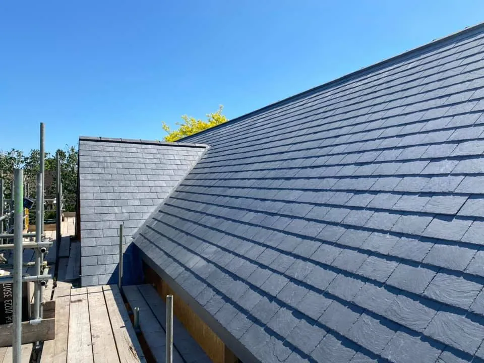 Newly laid slate pitched roof against a clear blue sky